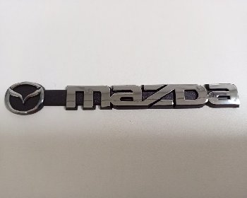 Шильдик металлопластик MAZDA + эмблема, серебро 